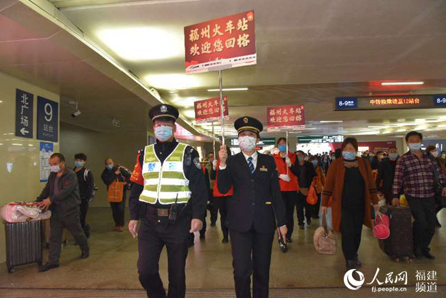 福州火車站黨團(tuán)員青年突擊隊和值班鐵路民警引導(dǎo)旅客出站。 江曲攝
