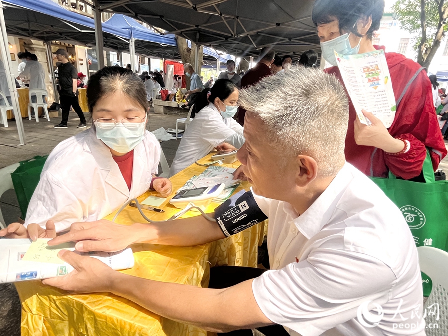 一位市民在展位前測(cè)量血壓。人民網(wǎng) 錢嘉禾攝