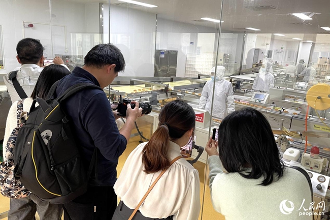 參賽記者參訪盼盼食品有限公司生產(chǎn)車間，拍攝取材。人民網(wǎng) 謝星宇攝