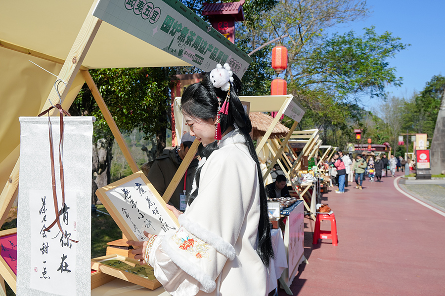 身穿漢服的游客駐足欣賞工藝品。武夷山市數(shù)字武夷電子商務(wù)發(fā)展有限公司供圖