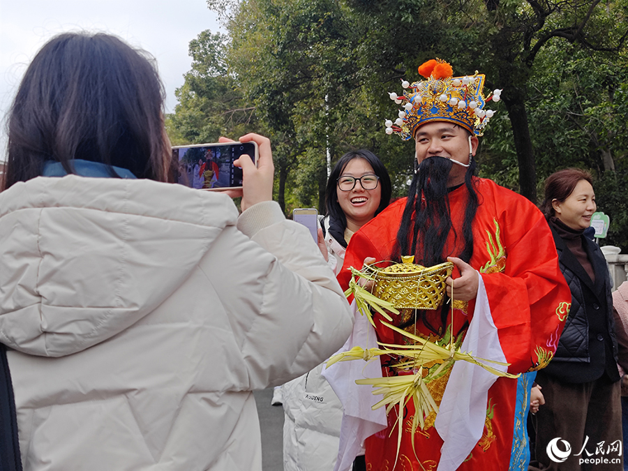 游客在西街路遇“財神爺”。人民網(wǎng) 黃東儀攝