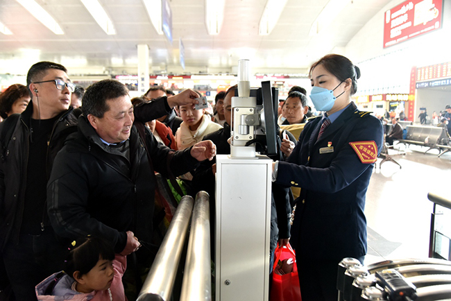 福州火車站工作人員正在幫助旅客快速檢票進(jìn)站乘車。江曲攝