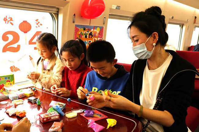 高鐵列車上，家長(zhǎng)帶孩子在“遛娃艙”玩玩具。陳月攝
