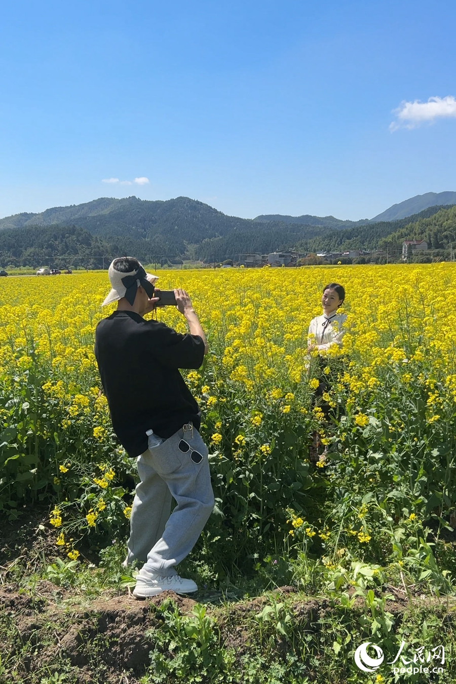 游人們在油菜花海中打卡留念。人民網(wǎng)記者 蘭志飛攝