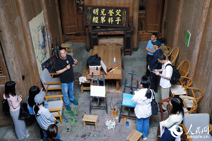雙溪鎮(zhèn)薛府文化藝術(shù)中心負(fù)責(zé)人程美信介紹古民居修復(fù)與活化利用等情況。人民網(wǎng) 李唯一攝