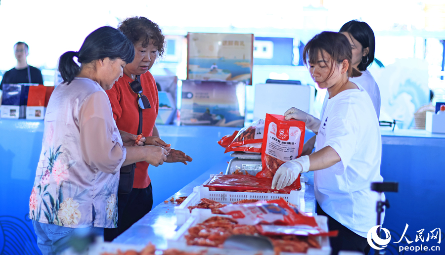 10.在澳角村，游客采購當(dāng)?shù)睾ｕr加工產(chǎn)品。人民網(wǎng) 李昌乾攝