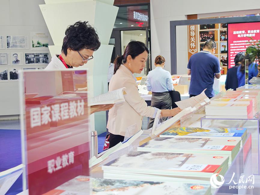 與會人員參觀成果展。據統(tǒng)計，目前中小學三科統(tǒng)編教材、高校思政課教材已全面融入習近平總書記地方重大實踐與重要論述有關內容。人民網 黃東儀攝