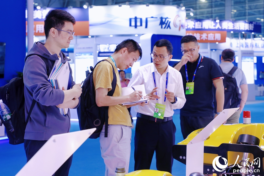 觀眾一邊同參展商交流一邊記筆記。人民網(wǎng) 李唯一攝