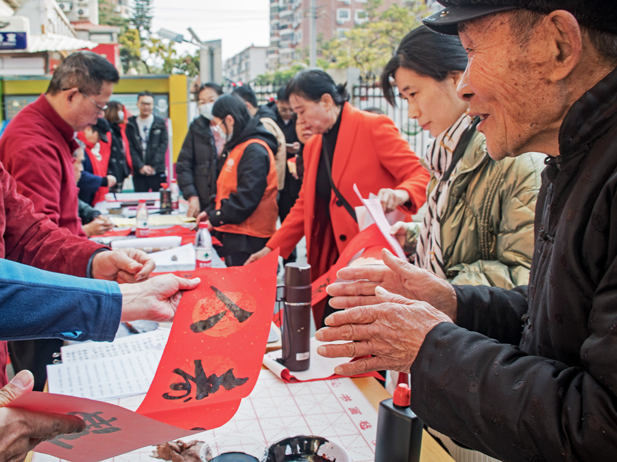 檳榔社區(qū)工作人員將寫好的春聯(lián)遞到居民手中。楊金木攝