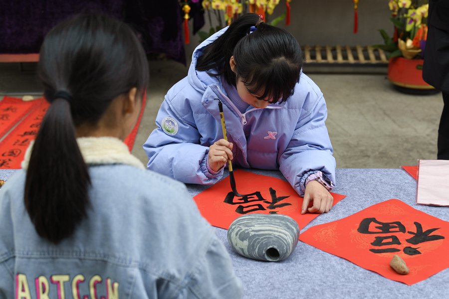 在廈門市思明區(qū)的商業(yè)街區(qū)，小朋友們自己動手寫“福”字贈送給過往路人。張瑜軍攝