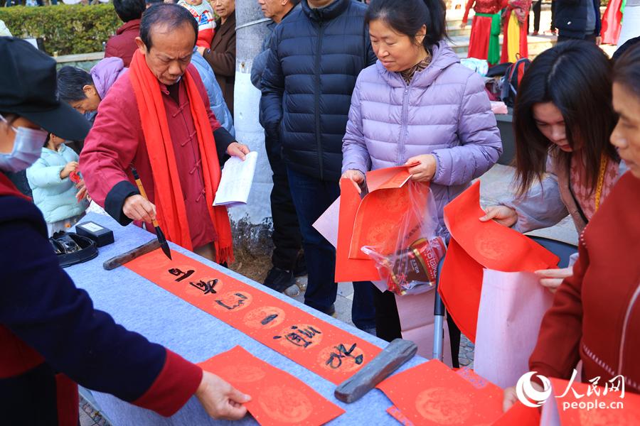 居民們紛紛自備紅紙，排隊(duì)領(lǐng)取鄭先生寫的“定制”版春聯(lián)。人民網(wǎng)記者 陳博攝