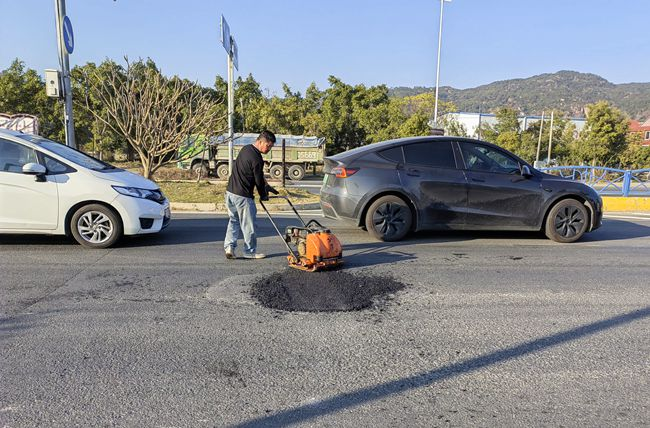 豐州鎮(zhèn)對榮武大橋至泉州動車站路段的破損路面進行修補。豐州鎮(zhèn)政府供圖