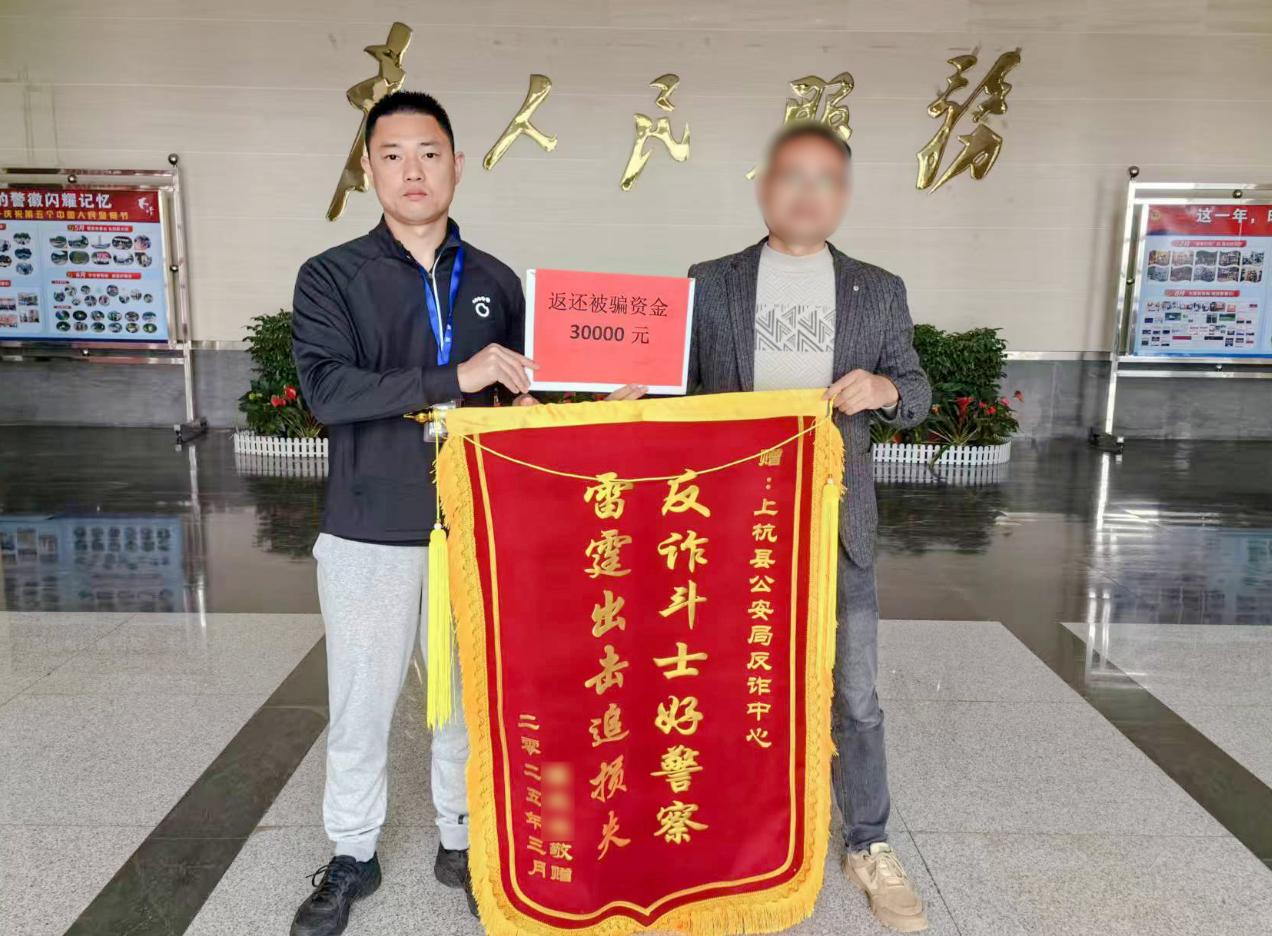 群眾送錦旗致謝民警追回被騙資金。羅龍輝攝