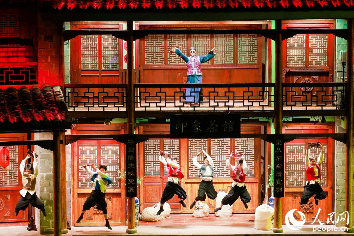 王龍濤（上）飾演茶掌柜帶領(lǐng)茶廠的伙計(jì)，為五湖四海的茶商計(jì)算“武夷四大名樅”的價(jià)格。人民網(wǎng) 李唯一攝