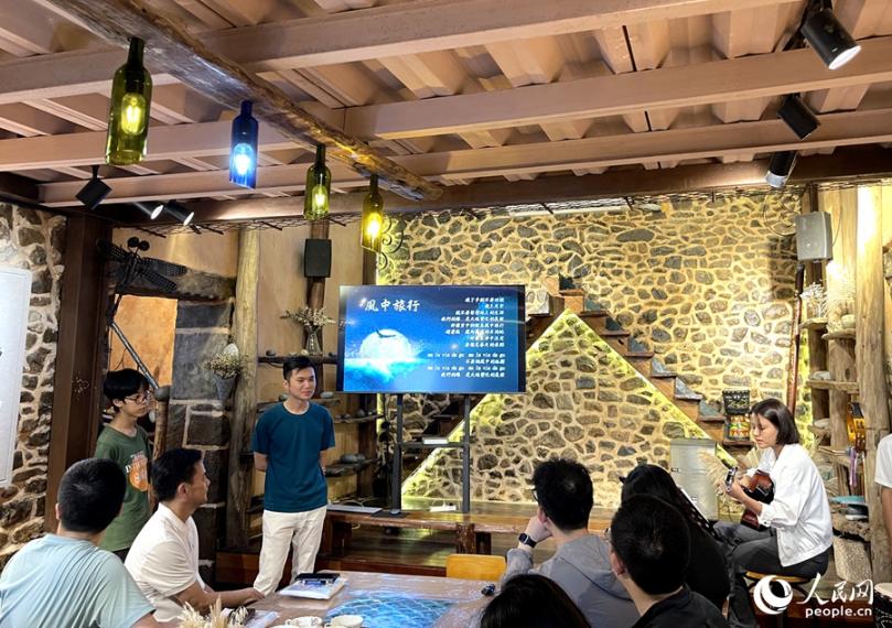 風(fēng)中旅行文創(chuàng)工坊里，主理人正在用歌聲歡迎遠(yuǎn)道而來的客人。人民網(wǎng)記者 陳藍(lán)燕攝