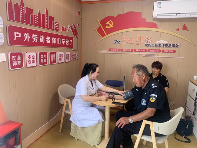 業(yè)務(wù)骨干在黨群暖心驛站內(nèi)為戶外勞動者免費(fèi)義診