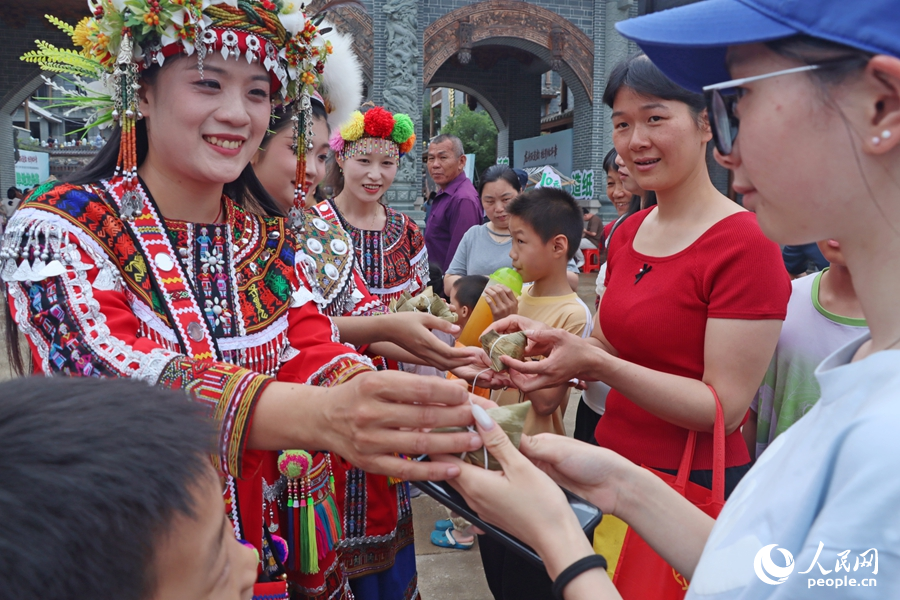 為游客免費派發(fā)“烏米粽”。人民網(wǎng) 李昌乾攝