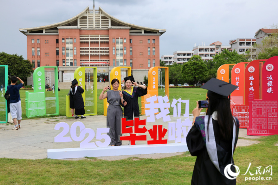 畢業(yè)生與家長(zhǎng)合影留念。人民網(wǎng)記者 陳博攝