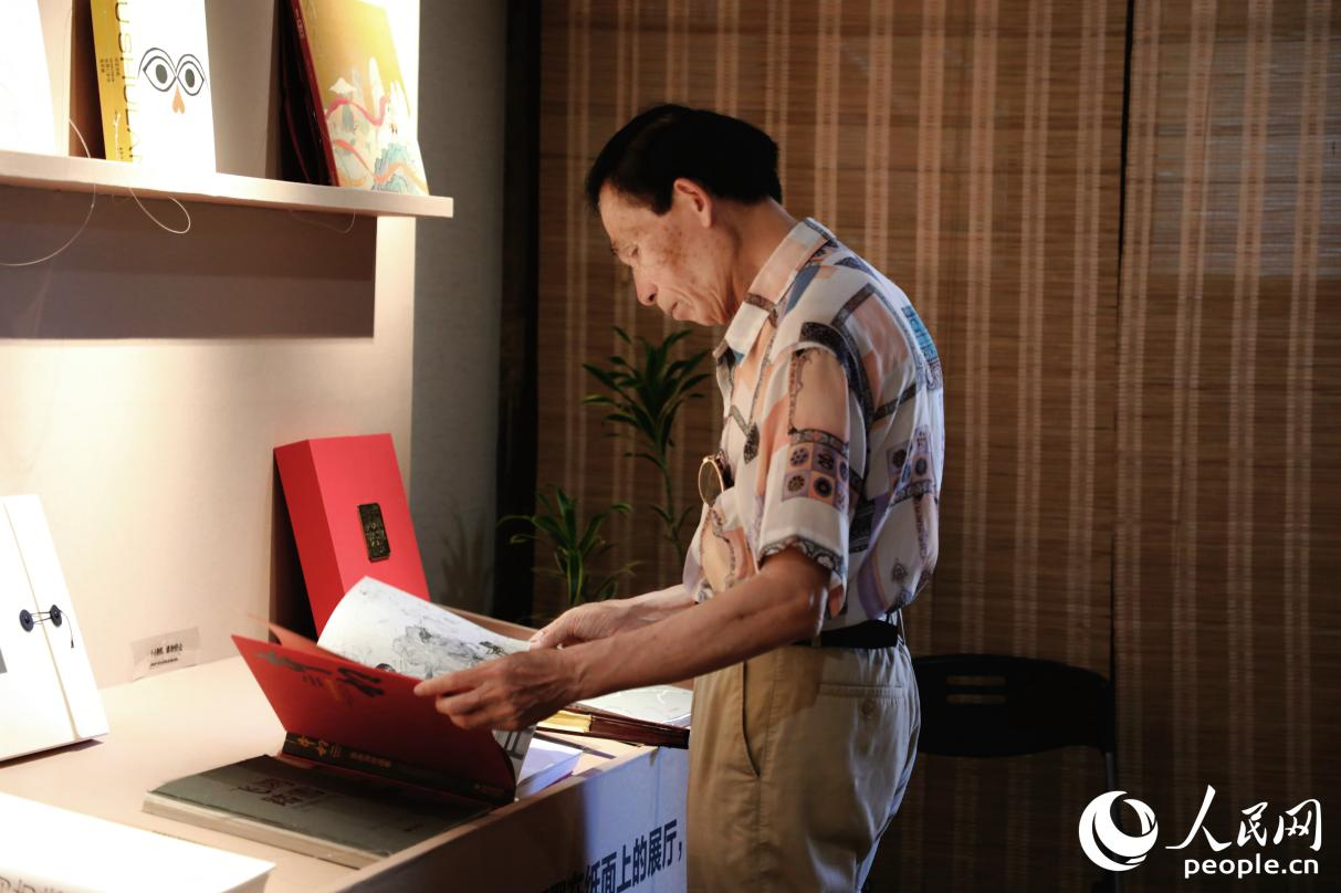 一位老人翻閱展出書(shū)籍。人民網(wǎng) 李唯一攝
