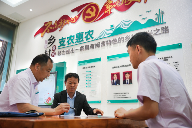 農(nóng)行工作人員在“惠農(nóng)服務旗艦店”暨“李文慰勞模工作室”向農(nóng)戶介紹農(nóng)戶貸款