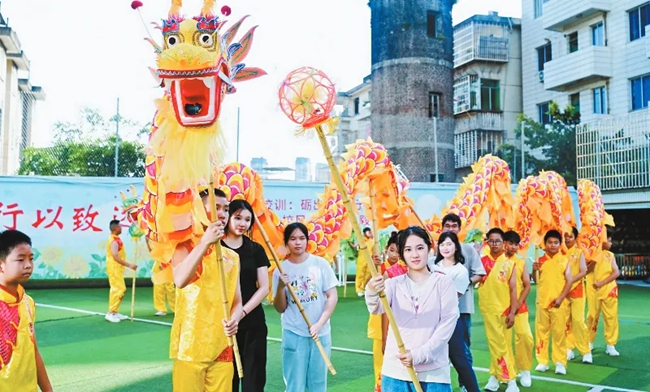 營員們在龍巖學(xué)院附屬小學(xué)與學(xué)生一同舞龍。龍巖市融媒體中心供圖