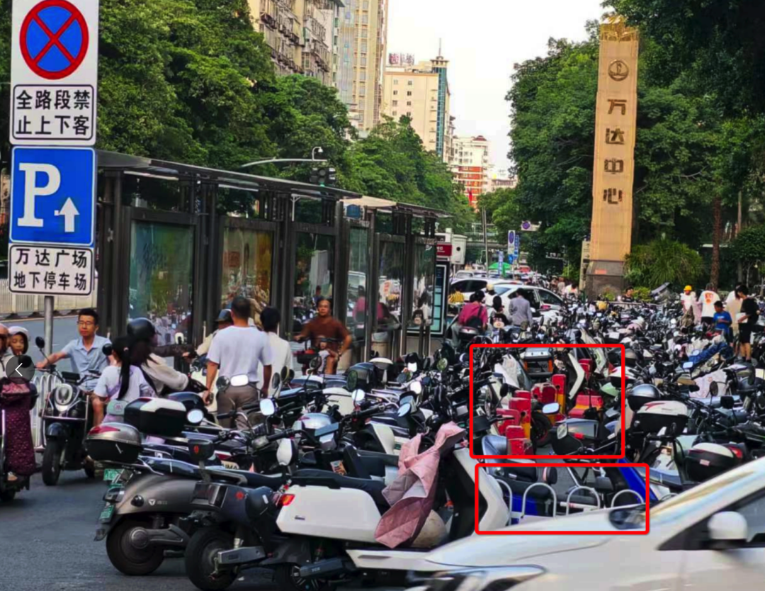浦西公交站背后路段設(shè)置了非機(jī)動車停車區(qū)域，但仍有大量電動車直接停放在白色護(hù)欄和紅色隔離墩（紅框位置）外的非機(jī)動車道上。李先生攝于7月2日