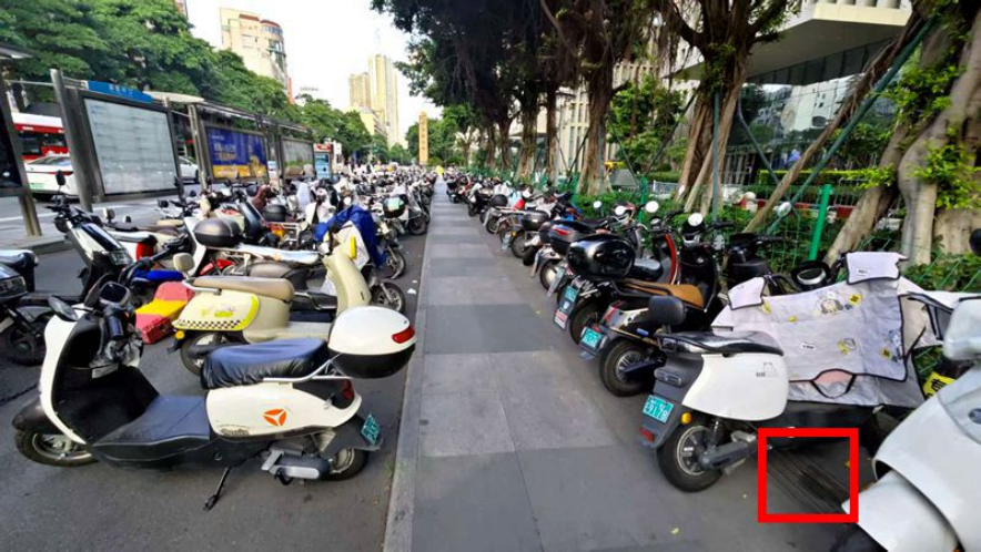 在浦西公交站背后的人行道上，也有不少電動車停放，且完全擋住盲道（紅框位置）。李先生攝于7月6日